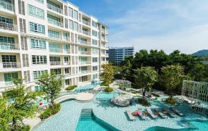 a large building with a swimming pool in front of it at Summer Huahin Condo classic room pool view in Hua Hin