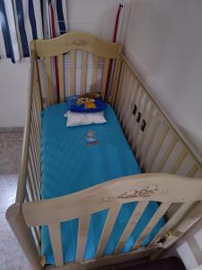 ein Holzbett mit einer blauen Decke in einem Zimmer in der Unterkunft Cosy apartment Acropolis Point-3 in Athen