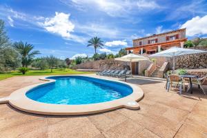 une piscine avec une table et des chaises ainsi qu'une maison dans l'établissement Can Mirló, à Marratxí 