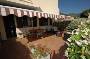 un patio con mesa, sillas y flores en Oleandro en Marina di Campo