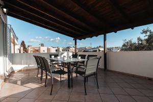 a patio with a table and chairs on a roof at Blue Riviera villas & suites - Alimos 2 in Athens