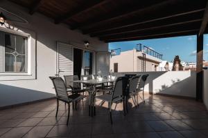 un patio con tavolo e sedie sul balcone. di Blue Riviera villas & suites - Alimos 2 ad Atene
