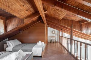 a bedroom with two beds in a room with wooden ceilings at Blue Riviera villas & suites - Alimos 2 in Athens