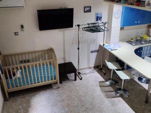 アテネにあるCosy apartment Acropolis Point-3の病室にはベビーベッド、シンク、テレビが備わります。