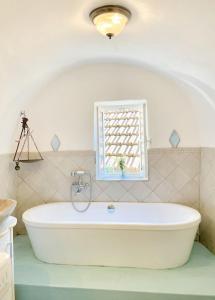 een badkamer met een bad en een raam bij Casa Via Orsini Isolabona Liguria Italy Sleeps 5 in Isolabona