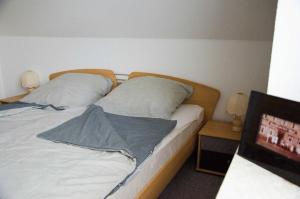 een slaapkamer met 2 bedden en een televisie bij Ferienwohnung Janto in Hooksiel