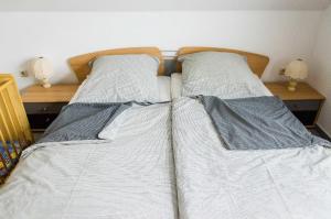 2 bedden in een slaapkamer met witte lakens en kussens bij Ferienwohnung Janto in Hooksiel