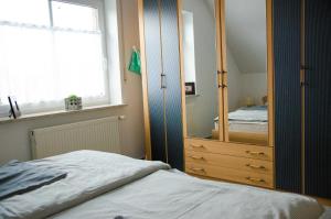 een slaapkamer met een grote spiegel en een bed bij Ferienwohnung Janto in Hooksiel