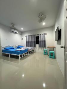 a hospital room with two beds and a tv at บ้านคุณย่า in Rayong