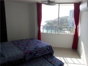 a bedroom with a bed and a window with a view at Apartamento En El Rodadero in Santa Marta
