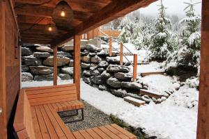 un porche de una cabaña con nieve en el suelo en Chalet Coquette Vigny^Hadley, en Saint-Michel-de-Maurienne