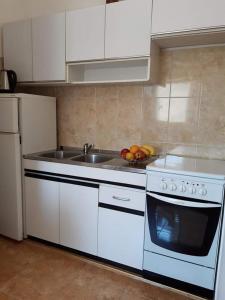 kuchnia ze zlewem i białą płytą kuchenną w obiekcie Apartment in Novalja with sea view, terrace, WiFi 3572-2 w Novalji
