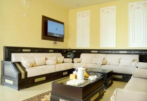 a living room with a couch and a tv at Jabal Al Akhdar Grand Hotel in Jabal Al Akhdar