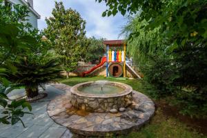 un parque infantil en un patio con una pequeña fuente en Apartment in Okrug Gornji with pool, terrace, AC, WiFi, washing machine 3436-5, en Trogir