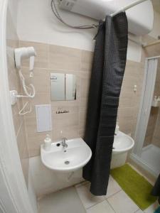 baño con lavabo y cortina de ducha en ApartHostel Brno, en Brno