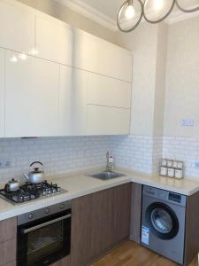 a kitchen with a stove and a sink and a washing machine at Sumgait Boulevard in Sumqayıt
