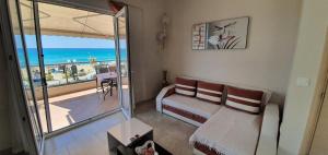 salon z kanapą i balkonem z widokiem na ocean w obiekcie Terra Kotta w mieście Paralia Vrachou