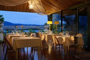 a restaurant with white tables and chairs with a view at Hotel Ristorante Sogno in San Felice del Benaco