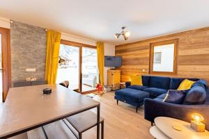 een woonkamer met een blauwe bank en een tafel bij Stylish 2 bed apartment near Les Prodains Gondola in Morzine