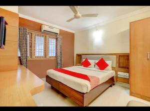 a bedroom with a large bed with red pillows at HOTEL MALABAR PLAZA in Chennai