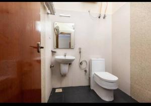 a bathroom with a toilet and a sink at HOTEL MALABAR PLAZA in Chennai