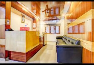 a waiting room with leather couches and a bar at HOTEL MALABAR PLAZA in Chennai