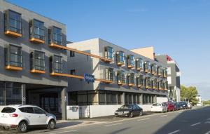 a building with cars parked in front of it on a street at Résidence Odalys Archipel in La Rochelle