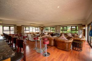a large living room with couches and tables and chairs at The Victoria Falls Deluxe Suites in Victoria Falls