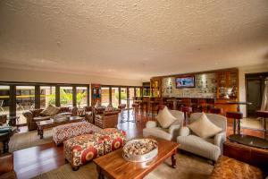 un ampio soggiorno con divani e bar di The Victoria Falls Deluxe Suites a Victoria Falls