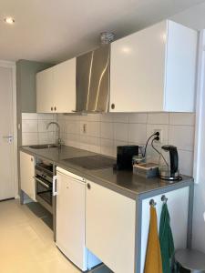 a kitchen with white cabinets and a counter top at B&B Berglust in Rotterdam