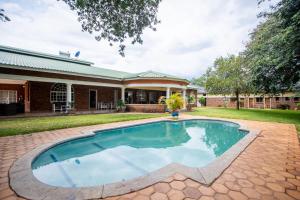 una piscina en el patio de una casa en The Victoria Falls Deluxe Suites en Victoria Falls