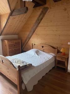 a bedroom with a bed in a wooden attic at Deux appartements individuels de 8 personne à 200 mètres des remontées mécaniques au centre du village in Saint-Sorlin-dʼArves