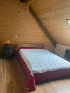 a bedroom with a bed in a wooden attic at Deux appartements individuels de 8 personne à 200 mètres des remontées mécaniques au centre du village in Saint-Sorlin-dʼArves +6 photos