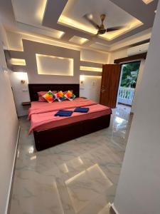 a bedroom with a large bed with pink sheets at TGI Guest Houses in Calangute