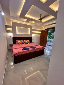 a bedroom with a large bed with red sheets at TGI Guest Houses in Calangute