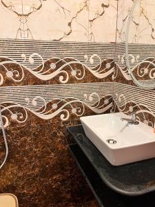 a bathroom with a white sink and a wall at TGI Guest Houses in Calangute +96 photos