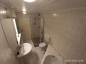 La salle de bains est pourvue de toilettes, d'un lavabo et d'une douche. dans l'établissement Komfortabler Bungalow, Husen 15 , 2 bis 4 Personen, Europa-Feriendorf, à Husen