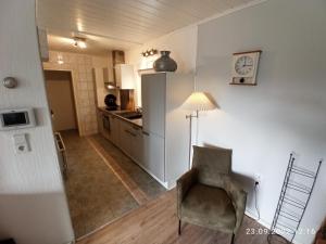 a living room with a chair and a kitchen at Komfortabler Bungalow, Husen 15 , 2 bis 4 Personen, Europa-Feriendorf in Husen