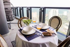 a table with a plate of food and wine glasses at Beachfront Suite Ocean-View Balcony 300Mb Fibre in Durban