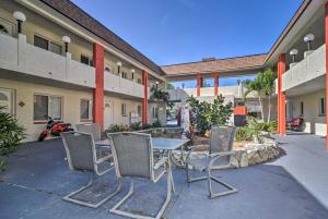 un patio con mesa y sillas frente a un edificio en Sunny Indian Rocks Beach Condo Steps to Gulf! en Clearwater Beach