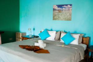 Lovina Vibes Hotel في Balian: غرفة زرقاء مع سرير وفوط عليه