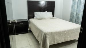 um quarto com uma cama com uma cabeceira preta em Hotel Tampico Express em Ciudad Madero