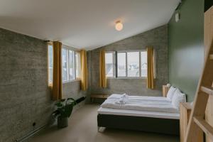 um quarto com uma cama e duas janelas em Trevarefabrikken em Henningsvær