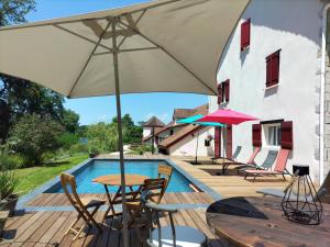 Un patio con una mesa y sillas y una sombrilla. en Le Moulin de Saubrigues, en Saubrigues 29 fotos más