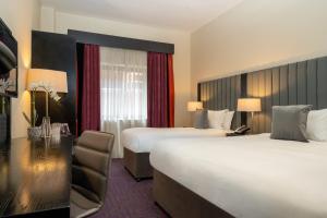 Voodi või voodid majutusasutuse The Trinity City Hotel toas