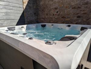 uma banheira branca com água azul em La Maison d'Emilie em Pfaffenheim