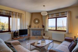 a living room with a couch and a coffee table at Helidonia Villas in Pigi