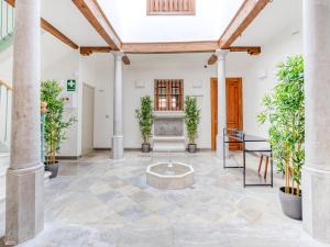 limehome Granada Calle Mirasol في غرناطة: غرفة معيشة بها اعمدة ونافورة