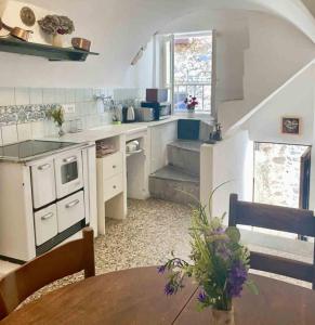 a kitchen with a table and a staircase in a room at Casa Celestine in Via Orsini Isolabona Liguria Italy Sleeps 5 in Isolabona