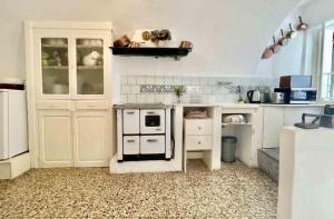 een keuken met een zwart-witte kachel bij Casa Via Orsini Isolabona Liguria Italy Sleeps 5 in Isolabona